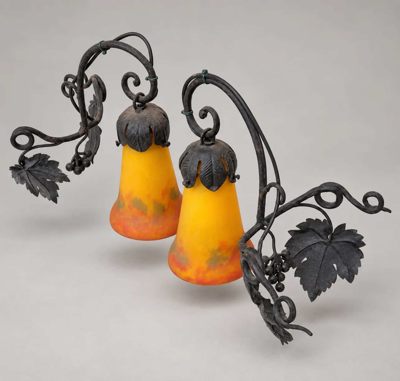Paire d’appliques en fer forgé, tulipes en pâte de verre signées G.V. de Croismare